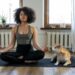 woman doing yoga beside her dog