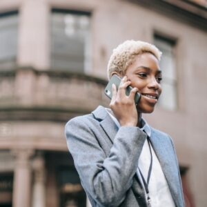 cheerful ethnic businesswoman talking on phone