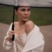 elegant woman holding transparent umbrella in rain