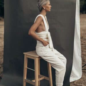 stylish woman sitting near gray textile