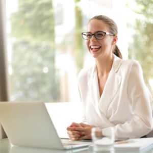 laughing businesswoman working in office with laptop