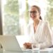 laughing businesswoman working in office with laptop