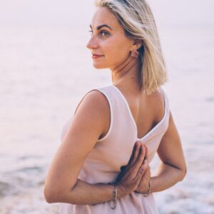 a woman in tank top with her hands together at the back