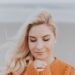 blonde haired woman in orange knitted long sleeved top