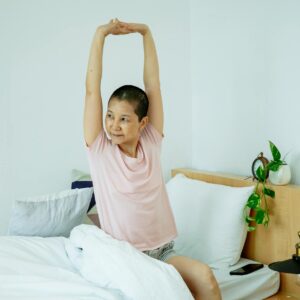 asian female stretching hands in bed