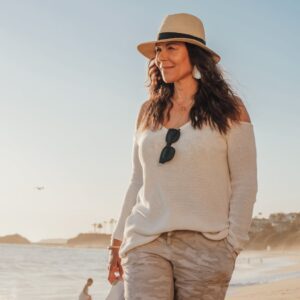 woman in white long sleeve shirt holding her shoes