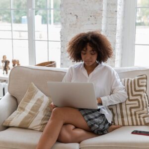 focused young african american lady working online on netbook at home