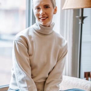 smiling lady in room on windowsill near window and lamp