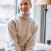 smiling lady in room on windowsill near window and lamp