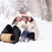 three women sitting on snow covered ground during day