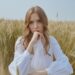 female sitting on chair in field in countryside